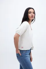 Remera color mostaza con escote en V, mangas abullonadas y corte cropped.