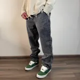 Pantalón jean gris oscuro de corte holgado.