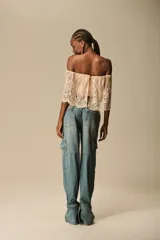 Pantalón jean celeste de corte ancho, con bolsillos cargo laterales y puños ajustables con hebillas.