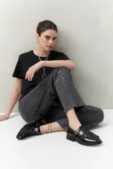 Jean gris oscuro de corte recto, tiro alto y calce relajado. Presenta apliques metálicos en los laterales.