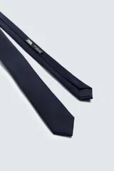 Corbata estrecha color azul marino confeccionada en tejido de seda con textura.