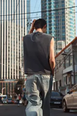 Musculosa negra con cuello redondo y sisas amplias. Estampado frontal con texto en color gris. Corte oversized.