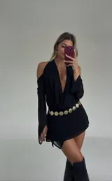 Minivestido negro con escote halter pronunciado y mangas largas con hombros descubiertos.