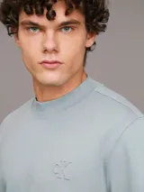 Buzo celeste de cuello redondo, marca Calvin Klein, con logo CK bordado en el pecho.