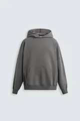Sudadera gris con capucha, corte holgado, bolsillo tipo canguro y terminaciones en rib.
