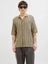 Polo de punto con fit relajado y diseño estructurado. Tejido estilo urbano con cuello tipo camisa, cierre con botones y mangas cortas.