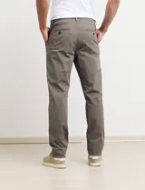 Pantalón largo de gabardina color verde medio, con corte slim fit y tobillos ajustados.