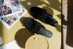 Mocasines tipo mule color beige, con detalle de cordones y ojales metálicos.