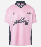 Remera rosa con cuello polo gris y rayas verticales. Estampado frontal con la palabra "gobline" en letras cursivas y la frase "in my best era". Diseño oversized con mangas cortas y recortes laterales en color negro.