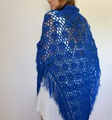 Chal azul tejido a crochet con diseño calado y flecos.