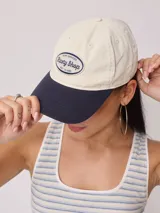Gorra de lona lavada color azul con visera curva y parche bordado con el logo de Rusty en el frente.