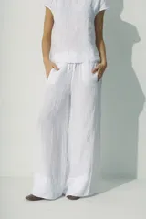 Pantalón blanco de lino, de corte palazzo y cintura con cordón ajustable.