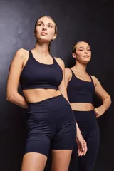 Top deportivo color verde militar con espalda cruzada en cuatro tiras y almohadillas removibles.