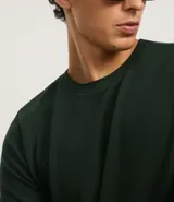 Remera azul marino de corte regular, confeccionada en tejido de piqué de algodón. Tiene cuello redondo con rib, mangas cortas y diseño liso.