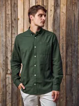 Camisa de manga larga color verde militar, confeccionada en tejido Oxford 100% algodón. Tiene cuello abotonado, cierre con botones y un bolsillo en el pecho. Corte slim fit.