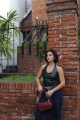 Top negro de cuero sintético con escote halter y espalda descubierta.