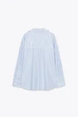 Camisa blanca con rayas verticales azul marino y lurex plateado, de corte recto, cuello solapa, escote en pico y cierre frontal con botones.