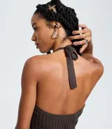 Vestido sin mangas de corte evasé, color verde oliva, con escote redondo y detalle de lazo en el cuello. El tejido presenta un efecto tricot texturizado acanalado.