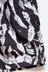 Short de baño negro con estampado de sirenas blancas y plantas marinas.