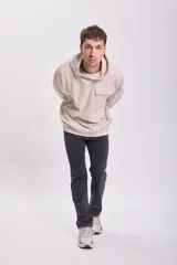 Canguro deportivo color beige con capucha, corte holgado y bolsillo tipo parche en el pecho.