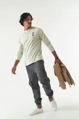 Remera de manga larga gris con cuello redondo y estampado con logo y texto en el frente.