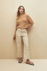 Pantalón recto color beige confeccionado en algodón, con tiro medio y bolsillos delanteros.