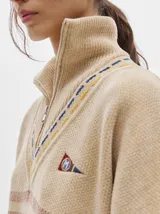 Sweater azul con cuello alto con medio cierre, textura tipo terciopelo y puños acanalados.