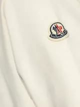 Sudadera color crema de algodón con cuello redondo y logo Moncler bordado en el pecho. Corte clásico con puños y bajo acanalados.