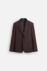 Blazer color borgoña de corte regular, con cuello de solapas de muesca, manga larga con puños abotonados, bolsillos de doble vivo en la cadera, bolsillo interior, abertura en el centro de la espalda y cierre frontal con botonadura.