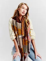 Pashmina grande con estampado tipo patchwork en tonos de gris, blanco y negro. Presenta un borde liso negro y flecos en los extremos.