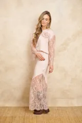Pollera larga color rosa pálido, de corte irregular y terminaciones en encaje floral.