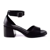Sandalia de cuero sintético color negro, con tira ancha sobre los dedos, pulsera con hebilla al tobillo y taco cuadrado bajo.