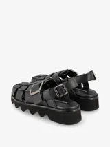 Sandalias plateadas con tiras entretejidas, hebilla lateral y suela track negra.