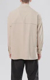 Camisa manga larga color beige, estilo técnica con múltiples bolsillos delanteros y un bolsillo en la parte inferior de la espalda, botones en cartera y mangas, calce oversize, confeccionada en textil ligero suave al tacto.