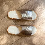 Sandalias bajas de cuero vacuno color negro, con suela de goma y horma de punta redonda. Producto de horma chica, se recomienda pedir un talle más.