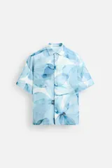 Camisa verde agua con estampado abstracto, corte relaxed fit, cuello solapa, manga corta y cierre frontal con botones.