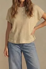 Remera color beige de tejido de punto, con corte holgado y mangas cortas.