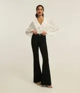 Pantalón flare negro de sarga con tiro alto, bolsillos delanteros y traseros, cierre con botón y cremallera, trabillas en la cintura.
