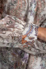 Camisa oversize de mangas largas con puños abotonados, cuello clásico y cierre frontal con botones. Estampado con motivos paisley en tonos pastel.