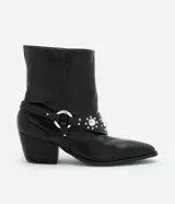 Bota corta de cuero sintético color negro, estilo western, con puntera fina, taco cuadrado y detalles de tachas plateadas.