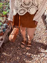 Sandalias bajas de cuero marrón con estampado animal print en las tiras.