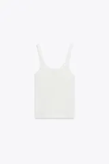 Top blanco de morley con escote redondo y tirantes. Detalle de flor en relieve combinada al tono.