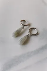 Aros colgantes de acero quirúrgico hipoalergénico con dije de piedra natural en forma de gota color azul oscuro.