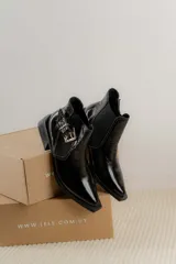 Botines Chelsea color beige con elásticos laterales negros, punta cuadrada, detalle de hebilla lateral y tacón bloque bajo.