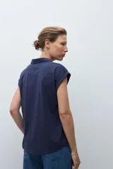 Remera de manga corta color rosa pálido, con cuello polo y escote en V con detalle de bordado en el borde.