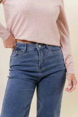 Jean de corte wide leg en color azul medio, con tiro medio, diseño de pierna amplia y fluida, y cinco bolsillos funcionales.