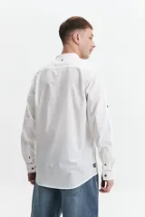 Camisa azul de manga larga con cuello mao y cartera abotonada.