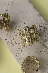 Anillo dorado con diseño geométrico calado.