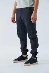 Pantalón cargo gris oscuro, corte slim, con cierre de botón y cremallera, trabillas para cinturón, bolsillos cargo con botón y puños ajustados.