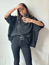 Remera negra de lino con bordado floral en el cuello y el ruedo. Corte amplio y mangas cortas.